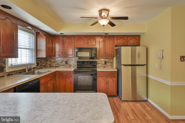 1514 Ravena St Unit D, Bethlehem, PA 18015 - kitchen featuring ceiling fan, tasteful backsplash, a sink, light wood finished floors, and black appliances