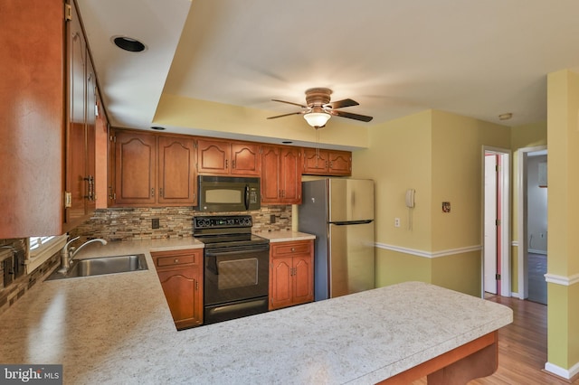 1514 Ravena St Unit D, Bethlehem, PA 18015 - kitchen with ceiling fan, a sink, a peninsula, decorative backsplash, and black appliances