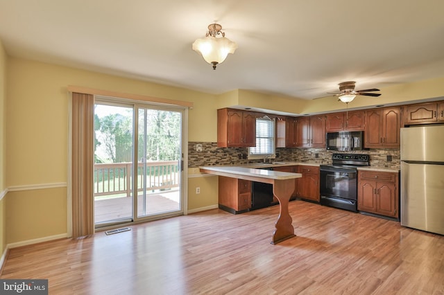 1514 Ravena St Unit D, Bethlehem, PA 18015 - kitchen with light countertops, a peninsula, black appliances, and tasteful backsplash