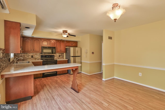 1514 Ravena St Unit D, Bethlehem, PA 18015 - kitchen featuring ceiling fan, brown cabinetry, tasteful backsplash, light countertops, and black appliances