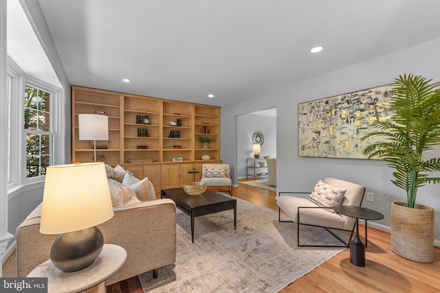 living area featuring baseboards, recessed lighting, and wood finished floors
