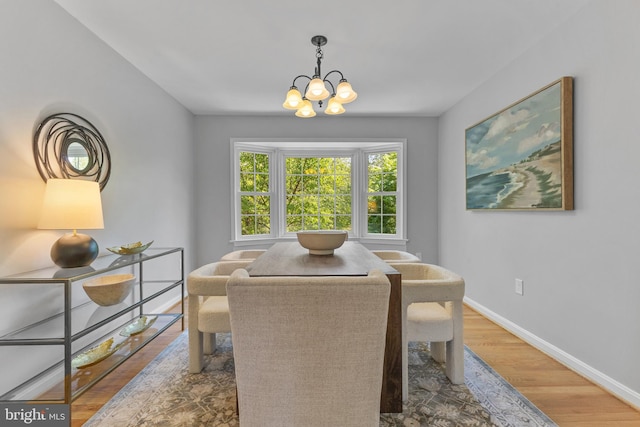dining room featuring baseboards, wood finished floors, and a chandelier