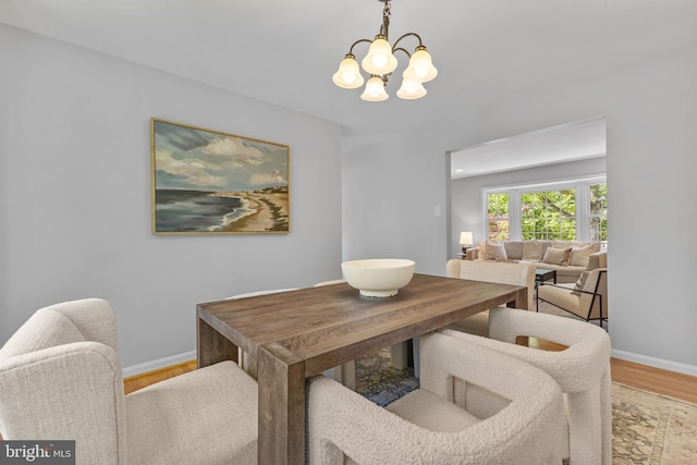 dining area featuring baseboards, an inviting chandelier, and wood finished floors