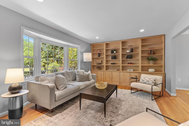 living area with light wood-style floors, baseboards, and recessed lighting