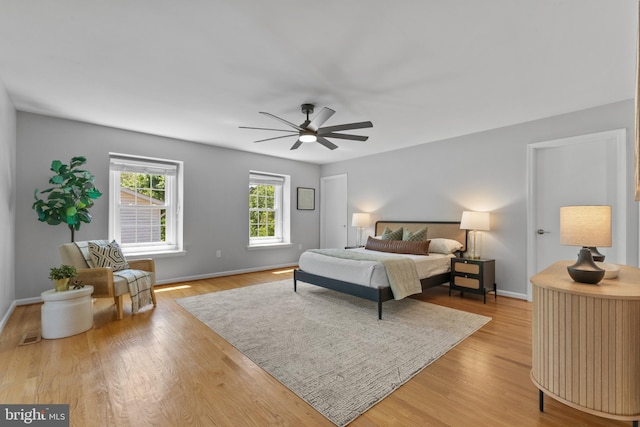 bedroom with baseboards, light wood finished floors, and ceiling fan