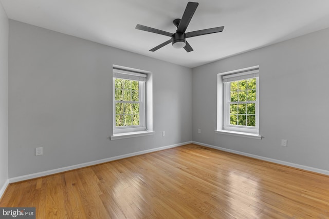 spare room featuring baseboards, ceiling fan, and wood finished floors
