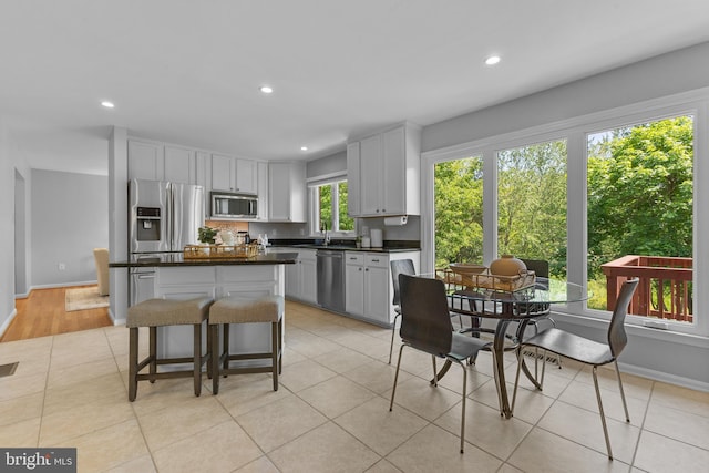 kitchen with a center island, recessed lighting, dark countertops, and stainless steel appliances