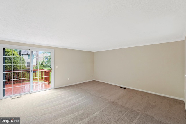 spare room with light colored carpet, baseboards, and crown molding
