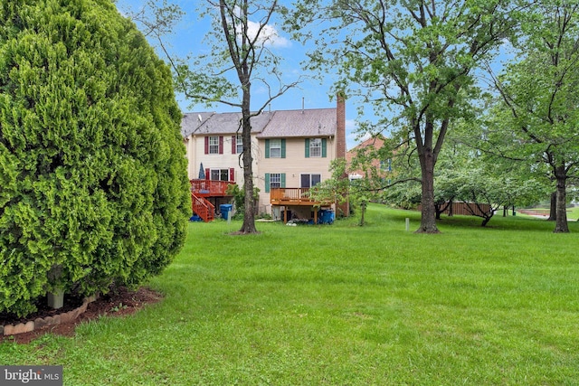 view of green lawn featuring a wooden deck