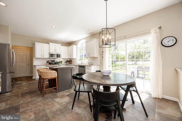 dining area featuring recessed lighting, baseboards, stone finish flooring, and a chandelier