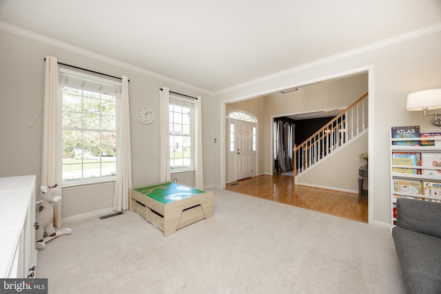 entryway featuring crown molding, stairs, visible vents, and light carpet