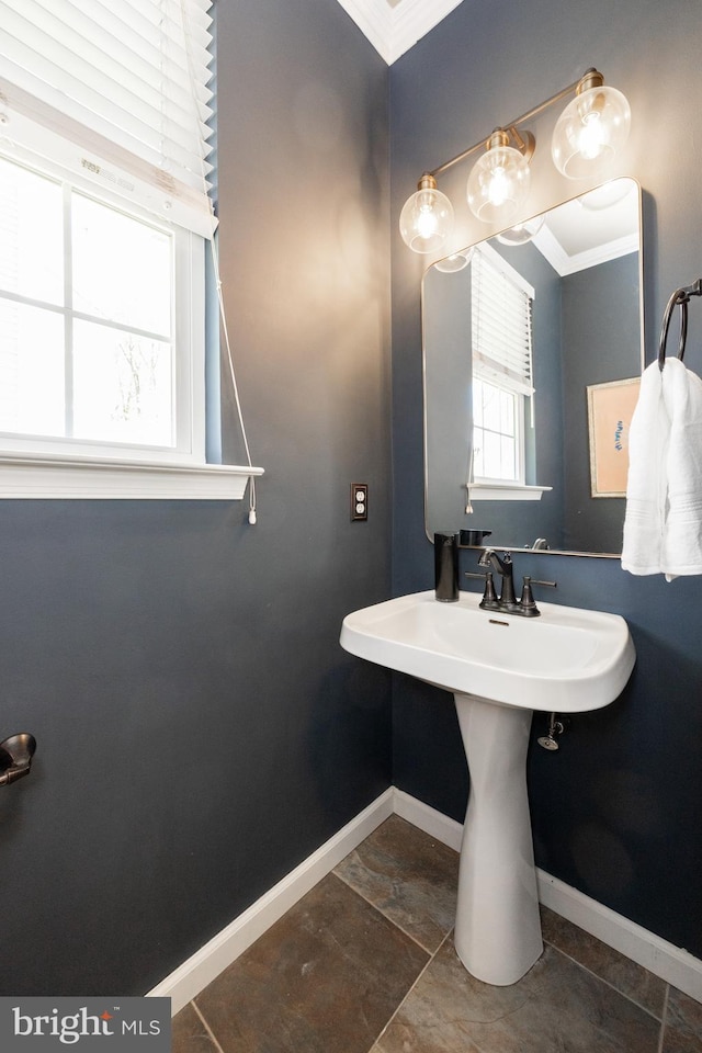 bathroom featuring crown molding and baseboards