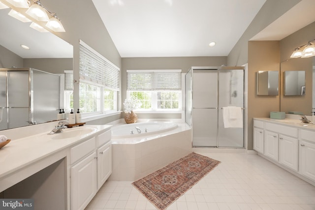 bathroom featuring vaulted ceiling, a sink, a garden tub, and a stall shower