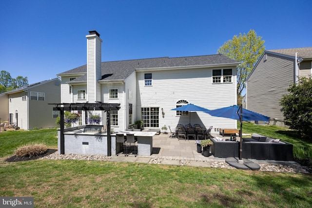 back of house featuring outdoor dry bar, a pergola, outdoor lounge area, a patio area, and a lawn