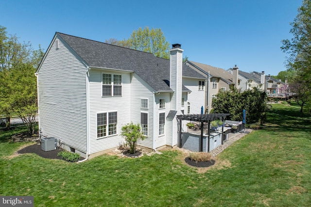 back of property featuring a yard, a pergola, a chimney, and a shingled roof