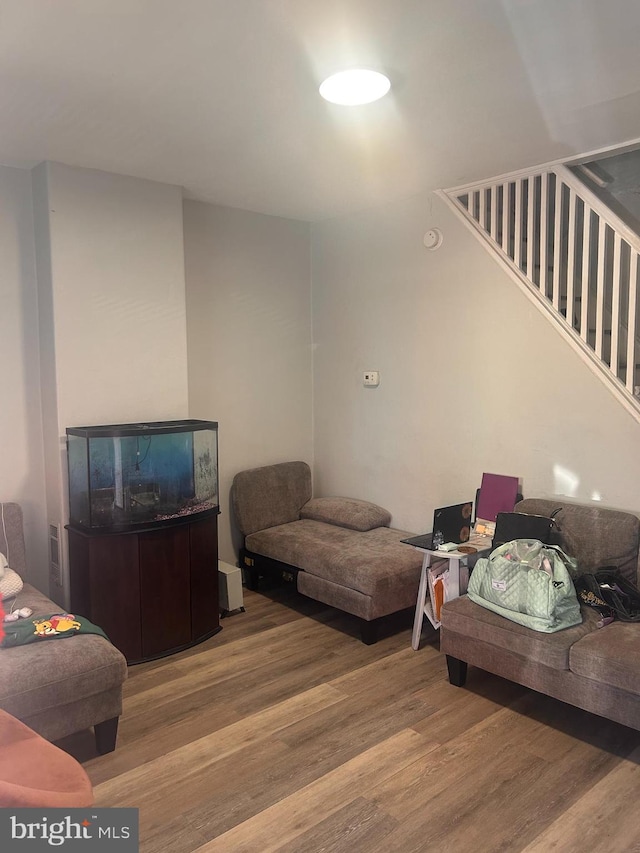 living area featuring stairs and wood finished floors