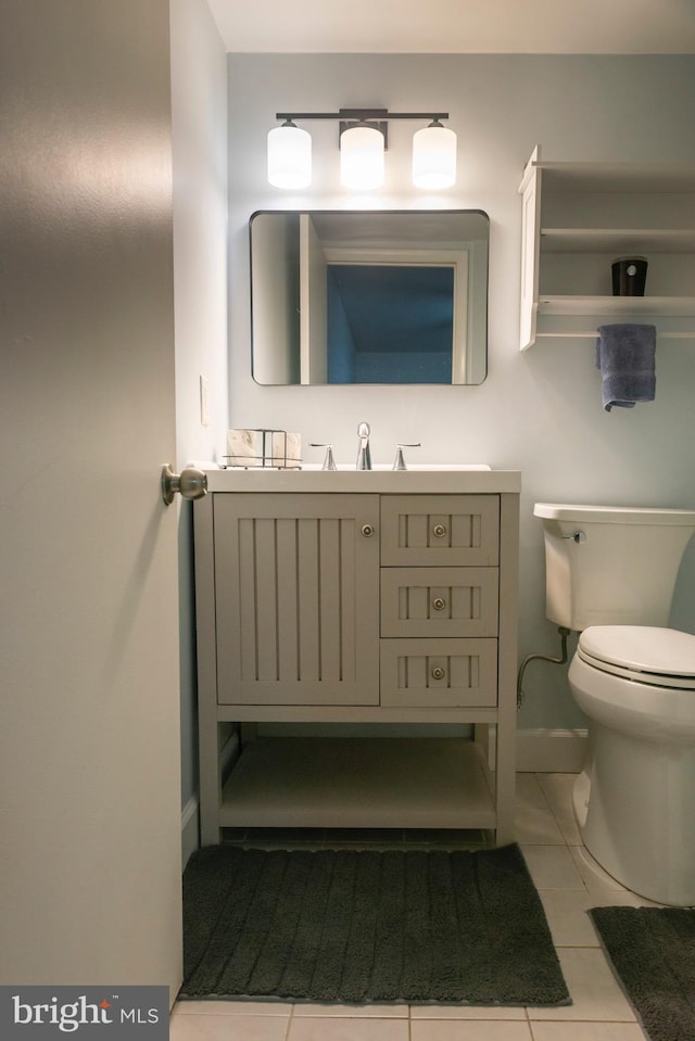 bathroom with toilet, baseboards, tile patterned flooring, and vanity