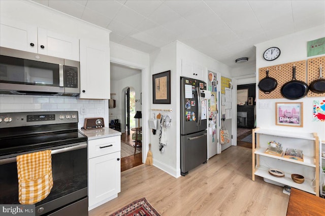 1708 Wrightfield Rd, Yardley, PA 19067 - kitchen with range with electric stovetop, stainless steel microwave, freestanding refrigerator, white cabinetry, and light wood-style flooring