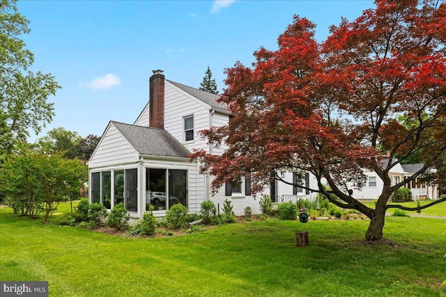 1708 Wrightfield Rd, Yardley, PA 19067 - back of house featuring a chimney, a lawn, a shingled roof, and a sunroom