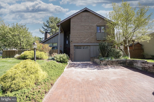 view of front of house featuring fence, a garage, decorative driveway, and brick siding