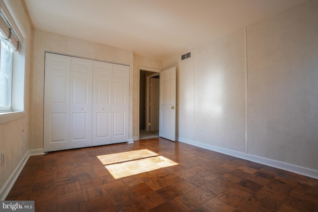unfurnished bedroom featuring baseboards, a closet, and visible vents
