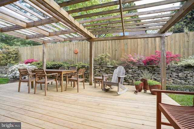 wooden deck with a pergola, fence, and outdoor dining area