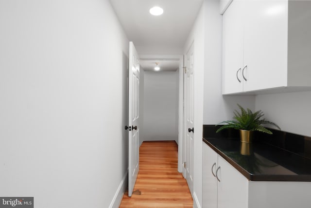 hallway featuring light wood-style floors and baseboards