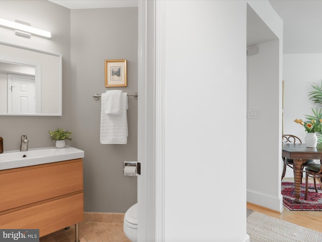 bathroom with vanity, baseboards, and toilet