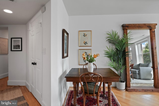 corridor with baseboards, recessed lighting, wood finished floors, and visible vents