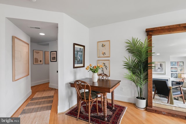 dining space featuring visible vents, baseboards, and wood finished floors