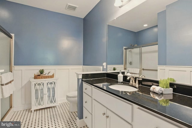 912 Moorings Cir Unit 8, Stevensville, MD 21666 - full bathroom featuring a stall shower, toilet, vanity, wainscoting, and a decorative wall