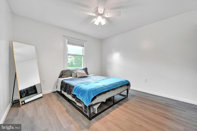 bedroom with wood finished floors, baseboards, and ceiling fan