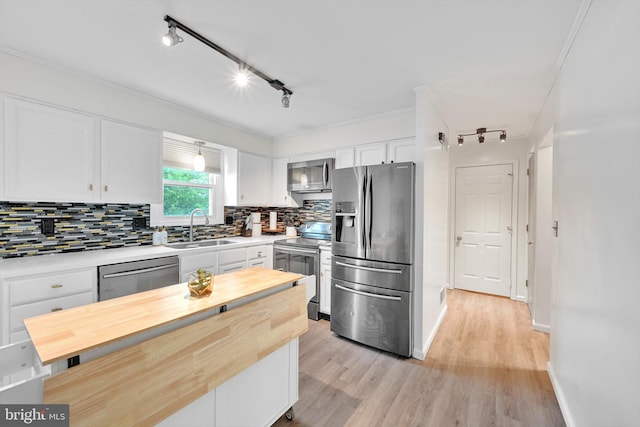 kitchen featuring appliances with stainless steel finishes, wooden counters, a sink, and white cabinetry