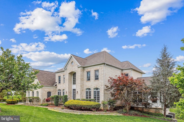 view of front of house with brick siding and a front lawn