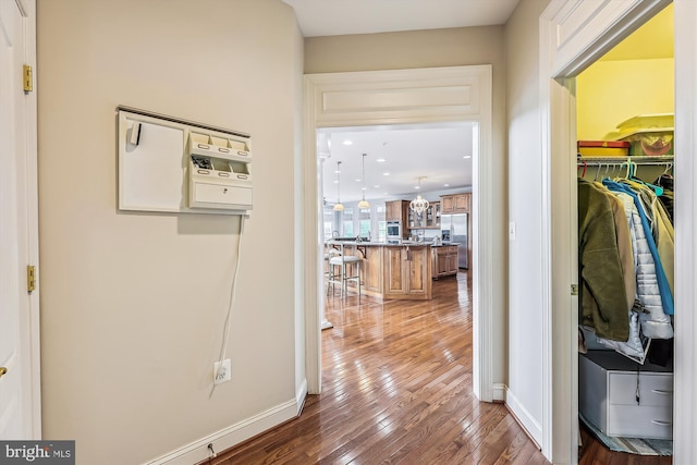 corridor with wood-type flooring, baseboards, and recessed lighting