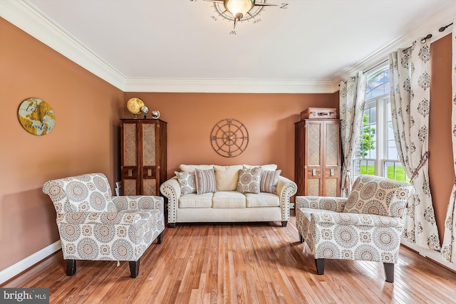living room with ornamental molding, wood-type flooring, and baseboards