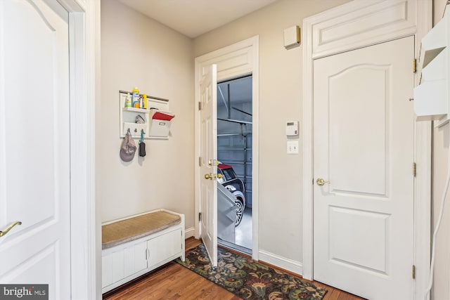 mudroom with dark wood-style flooring and baseboards