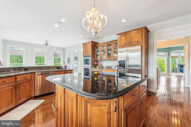 kitchen featuring stainless steel appliances, brown cabinetry, a sink, plenty of natural light, and recessed lighting