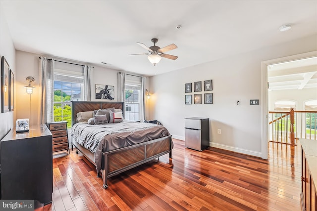 bedroom with hardwood / wood-style flooring, freestanding refrigerator, baseboards, and a ceiling fan