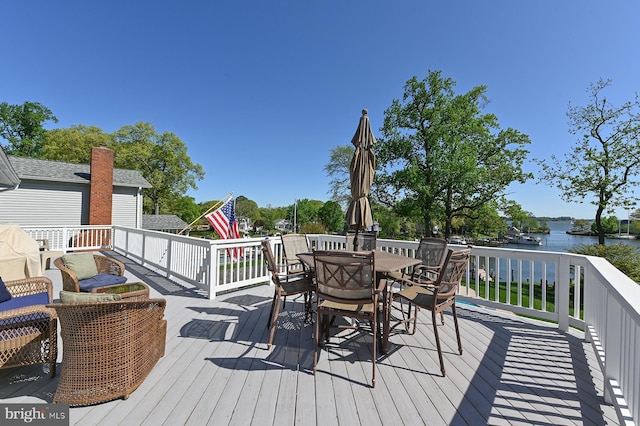 wooden terrace featuring a water view and outdoor dining space