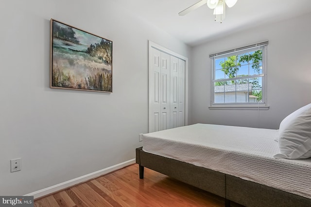 bedroom featuring baseboards, a ceiling fan, a closet, and wood finished floors