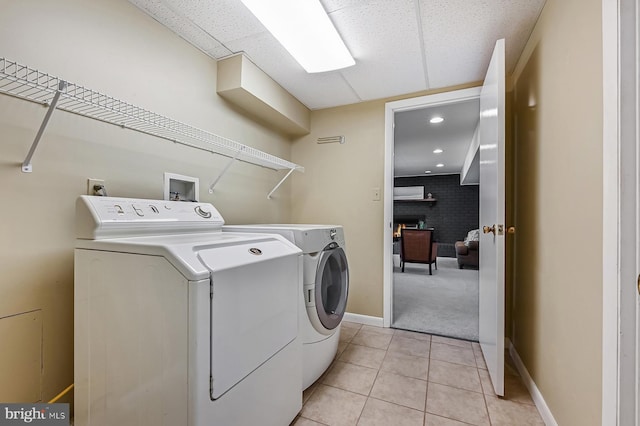 laundry area featuring independent washer and dryer, light tile patterned flooring, laundry area, light carpet, and baseboards