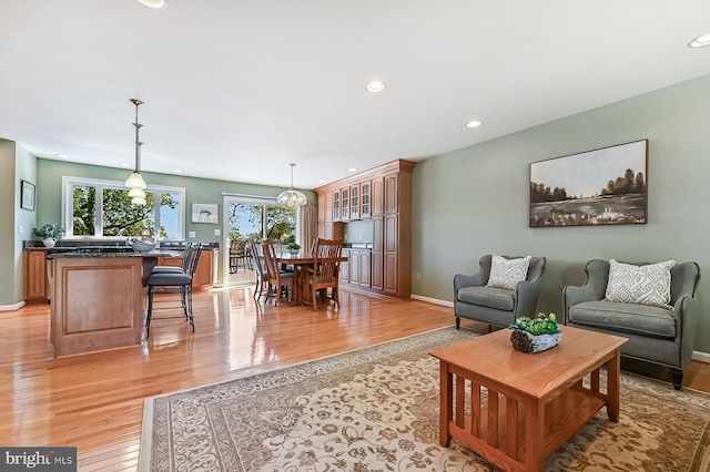 living room with baseboards, recessed lighting, and light wood-style flooring