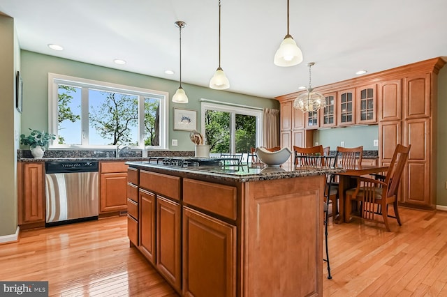 kitchen featuring dark stone countertops, a center island, recessed lighting, light wood-style flooring, and dishwasher