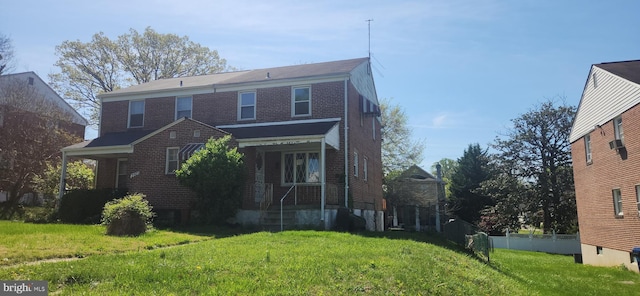 view of front of house featuring brick siding, a front lawn, and fence