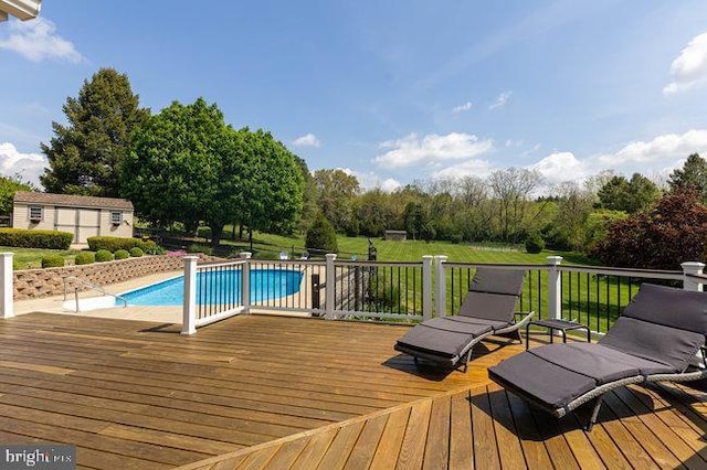 deck with a lawn and a fenced in pool
