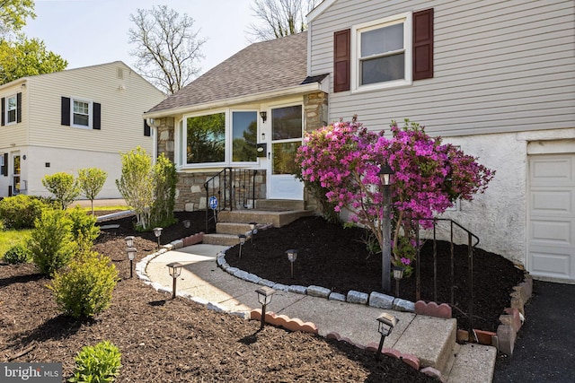 split level home with roof with shingles and stone siding