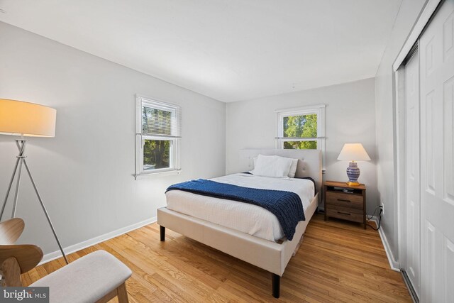 bedroom featuring baseboards, a closet, and light wood-style flooring