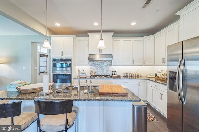 kitchen featuring visible vents, under cabinet range hood, white cabinets, a sink, and stainless steel appliances