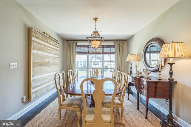 dining space featuring baseboards, wood finished floors, and a chandelier